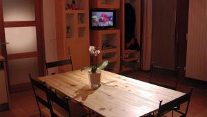 a wooden table with a vase of flowers on it at Baugnac in Lavalette