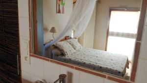 a bedroom with a mirror and a bed in front of a window at Gîte Baugnac N°2 in Lavalette