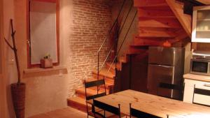 a kitchen with a wooden table and a staircase at Gîte Baugnac N°2 in Lavalette