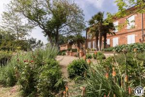 a garden in front of a brick building at Le parc des moutous in Aurin