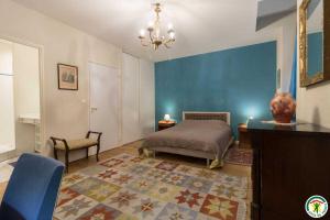 a bedroom with a bed and a blue wall at Le parc des moutous in Aurin +46 photos