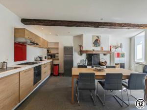 a kitchen with a table and chairs in a kitchen at Le cagire in Labarthe-Rivière