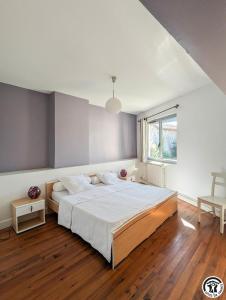 a bedroom with a large bed and a window at Le cagire in Labarthe-Rivière