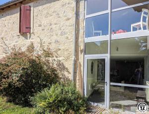 a house with a window and a chair in it at Le cagire in Labarthe-Rivière