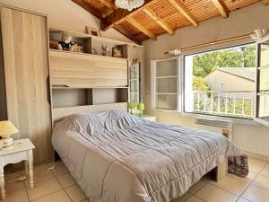 sypialnia z łóżkiem i dużym oknem w obiekcie Maison T3 avec mezzanine, piscine, parking, proche mer - Argelès-sur-Mer - FR-1-225-774 w Argelès-sur-Mer