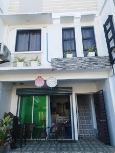 a white house with a patio with chairs and a table at Derichness in Tagbilaran City +5 photos