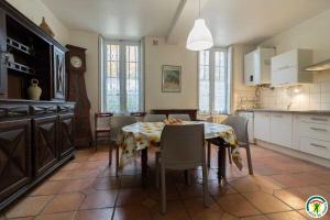 a kitchen with a table with chairs and a clock at Les pyrénées in Aurin