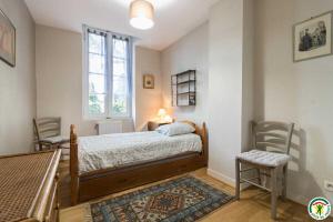 a bedroom with a bed with a window and two chairs at Les pyrénées in Aurin +49 photos