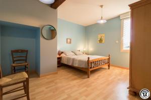 een slaapkamer met een bed en een stoel bij Saint martin in Beaumont-sur-Lèze