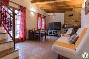a living room with a couch and a television at Au village in Roques Sur Garonne