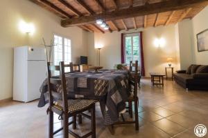a kitchen and living room with a table and chairs at Fuji in Pibrac