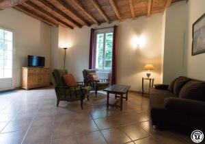 a living room with a couch and chairs and a tv at Fuji in Pibrac