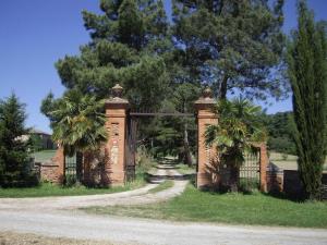 an entrance to a home with a brick fence and palm trees at Fuji in Pibrac