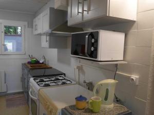a kitchen with a stove and a microwave at Les platanes in Aignes