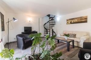 a living room with a spiral staircase in the background at Le hérisson in Aurignac