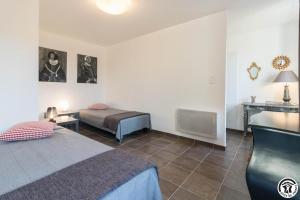 a bedroom with two beds and a table and a desk at Le hérisson in Aurignac