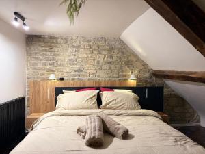 a bedroom with a large bed with a stone wall at Caen duplex T2 confort 18è s coeur de ville avec Vayny in Caen