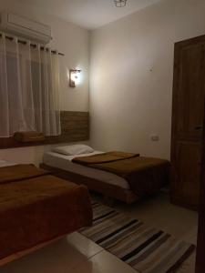 a room with two beds and a window with a window at Anne 2 dahab in Dahab