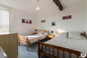 een slaapkamer met twee bedden en een raam bij Saint martin 2 in Beaumont-sur-Lèze