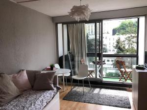 a living room with a couch and a large window at Studio opposite Thermes and Casino in Royat