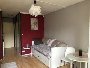 a bedroom with a white bed and a red wall at Studio opposite Thermes and Casino in Royat