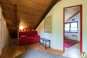 a living room with a red couch and a table at Le gîte de la coume in Garin
