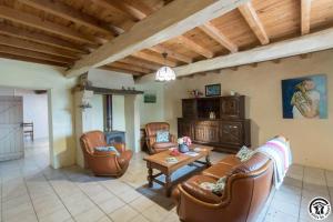 a living room with leather furniture and a table at Le gîte des oiseaux in Montbernard