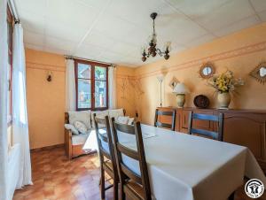 a dining room with a white table and chairs at Le pequerin in Oô +5 photos