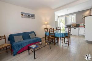 a living room with a blue couch and a table at Les lilas in Aussonne