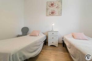 a bedroom with two beds and a dresser with a picture at Les lilas in Aussonne