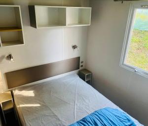 a bedroom with a large bed with a window at camping le clos fleuri in Vic-la-Gardiole +30 photos