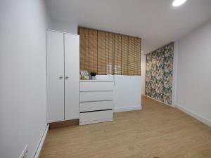 a kitchen with white cabinets and a large window at Apartamento La Ballena 2 - Las Huertas in Santoña +13 photos