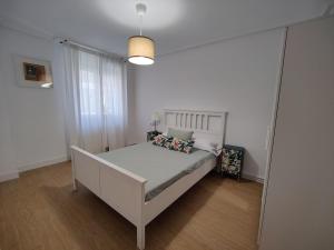 a bedroom with a white bed in a room at Apartamento La Ballena 2 - Las Huertas in Santoña