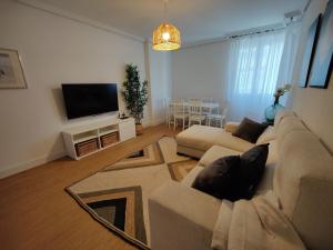 a living room with a couch and a flat screen tv at Apartamento La Ballena 2 - Las Huertas in Santoña
