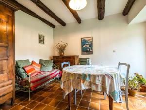 a dining room with a table and a couch at Le clos de bérande in Oô