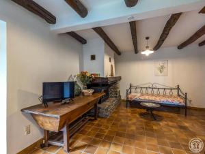 a bedroom with a bed and a desk with a television at Le clos de bérande in Oô