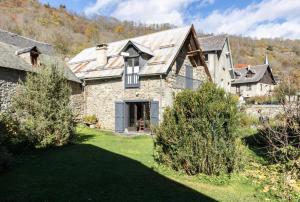 a stone house with a gambrel roof at Le clos de bérande in Oô