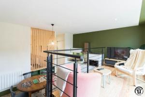 a living room with a glass staircase and a tv at La grange des rampeaux in Saint-Lys