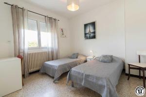 a bedroom with two beds and a window at Les hortensias in Aussonne