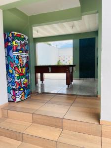 a room with a pool table and a colorful wall at CASA de PRAIA ESPETACULAR CHURRAS, PISCINA E SINUCA in Jacaraípe