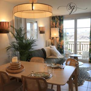 a living room with a couch and a table at Le terrier du Green appartement in Levernois