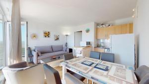 eine Küche und ein Wohnzimmer mit Tisch und Stühlen in der Unterkunft Le Reflet Marin in Les Bains