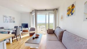 ein Wohnzimmer mit Sofa und Tisch in der Unterkunft Le Reflet Marin in Les Bains