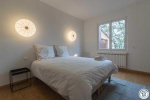 a bedroom with a large white bed with two windows at Maison jéricho in Saint-Ignan