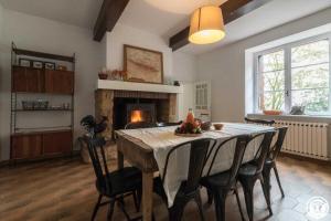 a dining room with a table with chairs and a fireplace at Maison jéricho in Saint-Ignan