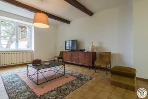 a living room with a table and a tv at Maison jéricho in Saint-Ignan