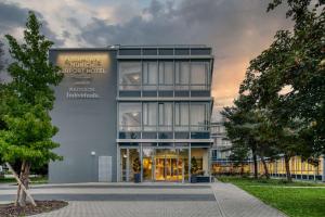 哈尔伯格摩斯Flightgate Munich Airport Hotel, a member of Radisson Individuals的一座有日落背景的办公楼