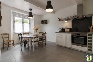 a kitchen with a table and chairs and a table and a table and a kitchen at Gîte de pene blanque in Arbas