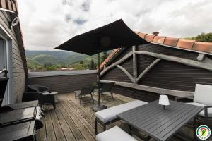a patio with a table and chairs and an umbrella at Gîte de pene blanque in Arbas