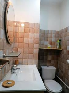 a bathroom with a sink and a toilet and a mirror at L'encantador in Saint-Mamet